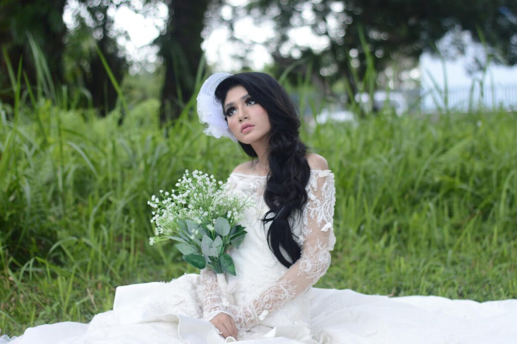 Women in wedding dress with a green field background